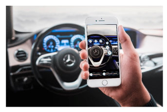 A hand holding a smartphone, scanning the inside of a Mercedes with it